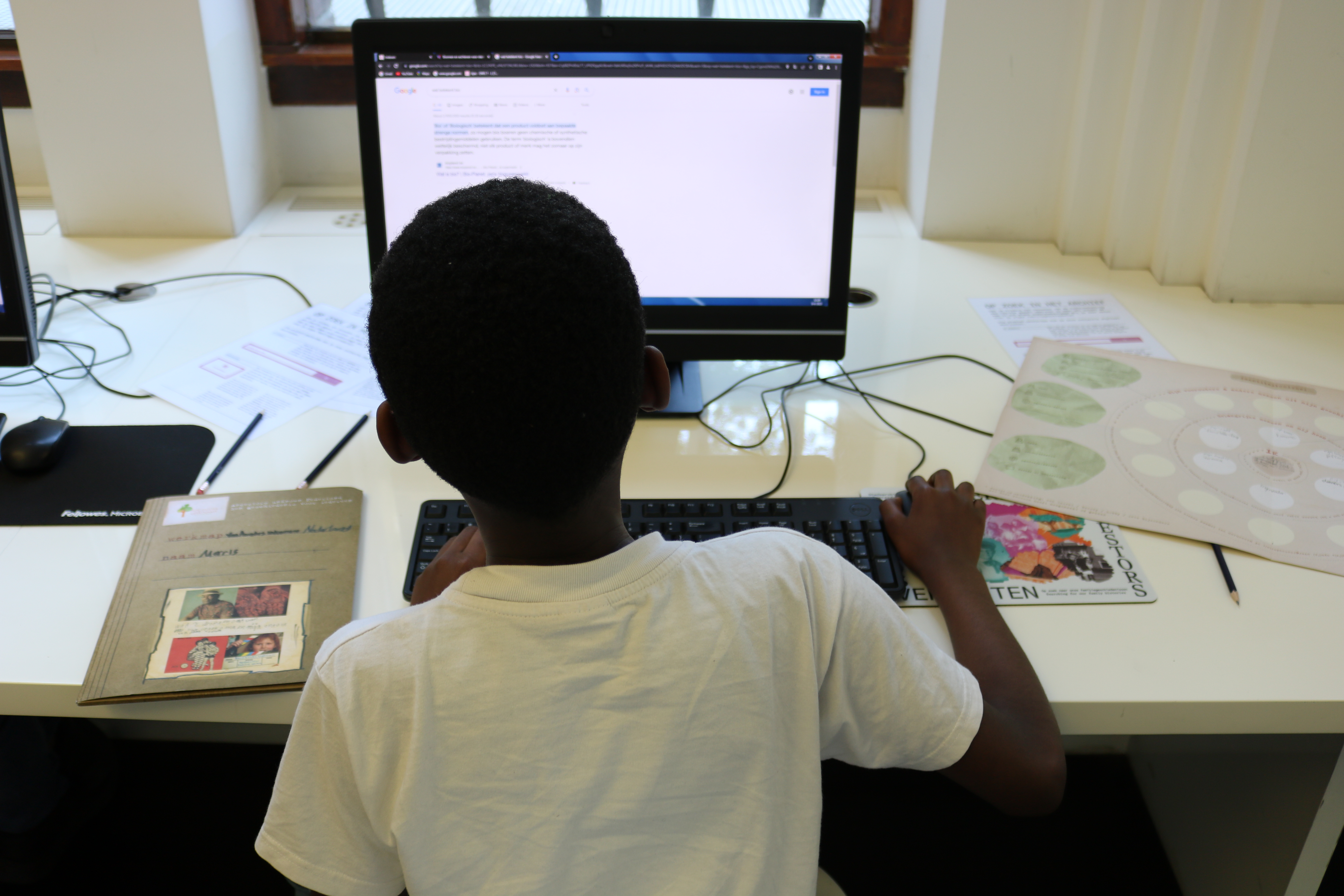 a boy looks at a computer screen with his back to the camera - enhance uk history education