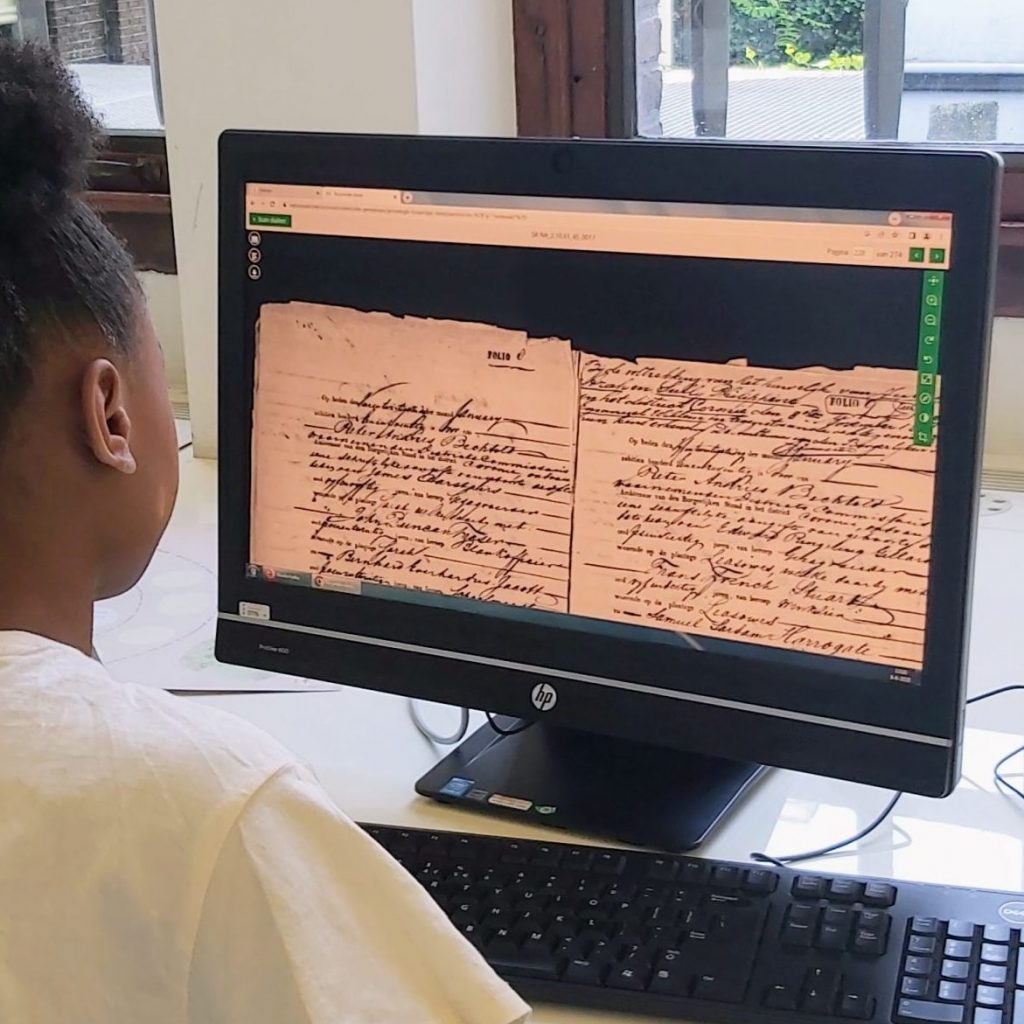 A young person looks at a computer that shows an archived document