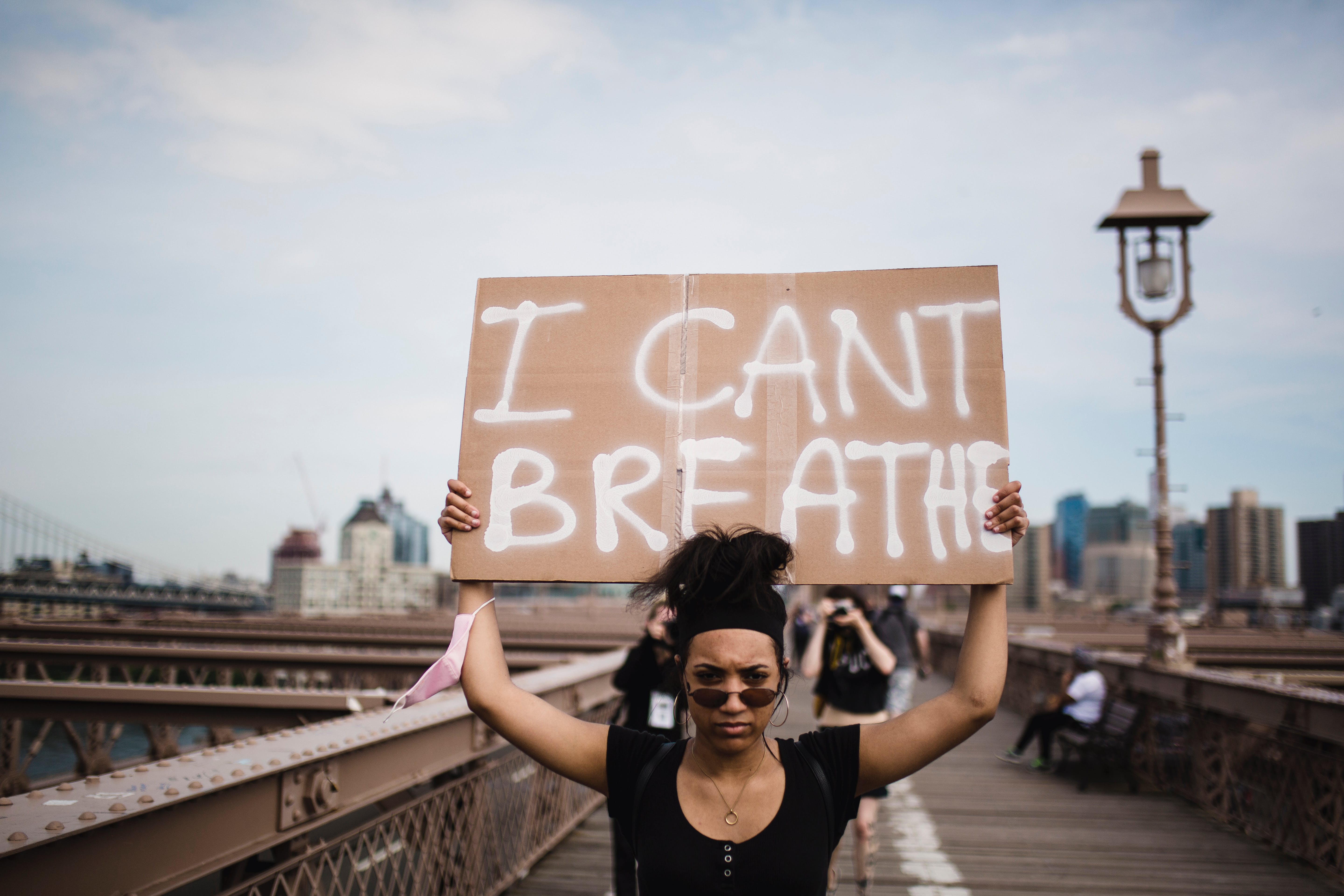 A protestor holding a sign, "I can't breathe"